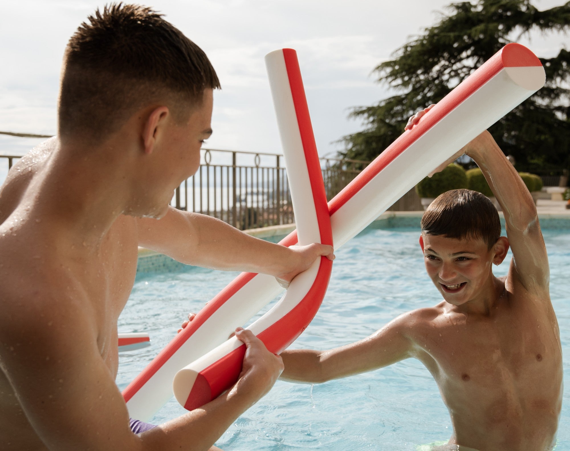 Deux garçons croisent leurs frites en duel dans la piscine
